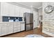 Kitchen with stainless steel fridge, white cabinets, and blue tiled backsplash at 849 Savile Ln, Fort Mill, SC 29715