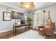 Home office with hardwood floors, a ceiling fan, natural light from the arched window, and an upholstered chair at 849 Savile Ln, Fort Mill, SC 29715