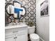 Stylish powder room with designer wallpaper, a decorative mirror and modern fixtures at 849 Savile Ln, Fort Mill, SC 29715