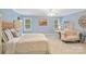 Light-filled bedroom with neutral walls, ceiling fan, and a comfortable seating area at 9027 Kirkley Ct, Charlotte, NC 28277