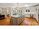 Bright kitchen with island cooktop, stainless appliances, and hardwood floors. Windows look out onto the backyard at 9027 Kirkley Ct, Charlotte, NC 28277