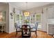 Cozy kitchen nook with hardwood floors, a round wood table, and large windows with patterned curtains at 9027 Kirkley Ct, Charlotte, NC 28277