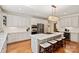 Bright kitchen featuring an island with a cooktop, stainless appliances, white cabinets, and hardwood floors at 9027 Kirkley Ct, Charlotte, NC 28277