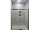 Bathroom with tile shower and glass door, featuring built-in shampoo and soap niche at 94 James Sw St, Concord, NC 28025