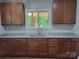 Well-lit kitchen featuring granite counters and stainless steel sink under a bright window at 94 James Sw St, Concord, NC 28025