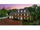 Stately brick home with manicured landscaping and a circular driveway at dusk at 1009 13Th Avenue Nw Pl # 19, Hickory, NC 28601