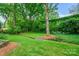 Secluded backyard with mature trees, lush greenery, and a small bridge over a stream at 1040 Goshen Pl, Charlotte, NC 28211