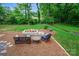 Outdoor seating area with fire pit and wooden furniture in a naturally landscaped backyard at 1040 Goshen Pl, Charlotte, NC 28211