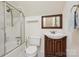 Traditional bathroom featuring a tub/shower, white tiled walls, and wood-trimmed vanity at 1040 Goshen Pl, Charlotte, NC 28211
