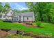 Home exterior featuring a deck with seating, fire pit, and a landscaped backyard with a small stream at 1040 Goshen Pl, Charlotte, NC 28211