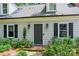 Home entrance with a well-kept lawn, flowering bushes, black door and modern exterior lights at 1040 Goshen Pl, Charlotte, NC 28211