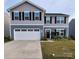 Charming two-story home with a two car garage, black shutters, and a welcoming front porch at 1047 Campbell Chase Sw Ln, Concord, NC 28025