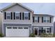 Inviting two-story home with a two car garage, black shutters, and a welcoming front porch at 1047 Campbell Chase Sw Ln, Concord, NC 28025