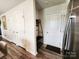 Hallway with wood-look flooring, white doors, and a metal and wood storage bench at 1047 Campbell Chase Sw Ln, Concord, NC 28025