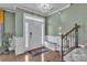 Welcoming foyer featuring hardwood floors, stairs, a decorative bench, and a bright front door at 1115 Macallum Nw Dr, Concord, NC 28027
