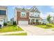 Charming two-story home with a brick and gray facade, well-manicured lawn, and a two-car garage at 1115 Macallum Nw Dr, Concord, NC 28027