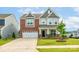 Charming two-story home with a brick and gray facade, well-manicured lawn, and a two-car garage at 1115 Macallum Nw Dr, Concord, NC 28027