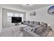Living room with a large gray sectional sofa, modern decor, and lots of sunlight at 1115 Macallum Nw Dr, Concord, NC 28027