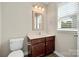 This bathroom features a wood vanity with marble top and a window that provides natural light at 1152 Mckee Farm Ln, Belmont, NC 28012