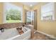 Relaxing bathroom with a soaking tub, separate shower, and large windows offering serene views at 1152 Mckee Farm Ln, Belmont, NC 28012