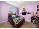 Bright bedroom features lavender walls, shelves, and a bed with a black and white checkered blanket at 1152 Mckee Farm Ln, Belmont, NC 28012