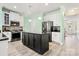 Bright kitchen with a black island, stainless appliances, white cabinets, and modern lighting at 1152 Mckee Farm Ln, Belmont, NC 28012