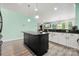 Open kitchen with dark island, granite countertops, white cabinets, and stainless appliances at 1152 Mckee Farm Ln, Belmont, NC 28012