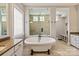 Bright bathroom featuring soaking tub, tiled floors, glass enclosed shower, and dual sinks at 1233 Ladera Dr, Waxhaw, NC 28173