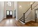 Bright foyer featuring hardwood floors, a staircase, and a front door with decorative glass panels at 1233 Ladera Dr, Waxhaw, NC 28173