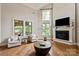 Bright living room with hardwood floors, fireplace, and large windows overlooking the yard at 1233 Ladera Dr, Waxhaw, NC 28173