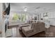 Bright living room with a fireplace, large windows, and comfortable seating area open to kitchen at 124 Slocumb Ln, Mooresville, NC 28117