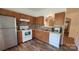 Kitchen features wood cabinets, white appliances, mosaic backsplash, and wood-look flooring at 12450 Stone Garden Dr, Huntersville, NC 28078
