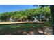 Community playground with green grass, tall shady trees, and playground equipment at 12450 Stone Garden Dr, Huntersville, NC 28078