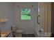 Bathroom with white cabinets, tile flooring, and a tub shower with natural light at 125 Heritage View Rd, Hickory, NC 28601