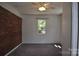 Bright bedroom featuring neutral carpet, a brick accent wall, and natural light from the window at 125 Heritage View Rd, Hickory, NC 28601