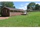 View of the brick home's exterior, featuring a metal roof and a backyard deck at 125 Heritage View Rd, Hickory, NC 28601
