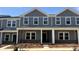 Charming two-story townhouse with gray siding, white trim, and a covered front porch in a well-maintained community at 135 Utility Ln, Mooresville, NC 28117