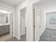 Hallway view showcasing bathroom access and bedroom entrances with plush gray carpet at 135 Utility Ln, Mooresville, NC 28117