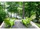 A cozy backyard seating area offers a tranquil view of the water in a private, wooded setting at 13934 Kings Carriage Ln, Charlotte, NC 28278