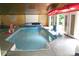 Indoor pool with kayaks, basketball hoops, lounge chairs, wooden ceiling, and doors to the outdoors at 13934 Kings Carriage Ln, Charlotte, NC 28278