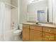 This bathroom offers a shower/tub, light cabinets, and vanity with a large mirror above at 14222 Richmond Park Ave, Charlotte, NC 28277