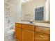 This bathroom features wood cabinets, a large mirror, and a shower with a bathtub at 14222 Richmond Park Ave, Charlotte, NC 28277