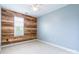 The room features carpet floors, pale blue walls, and a feature wall made of stained wood at 14222 Richmond Park Ave, Charlotte, NC 28277