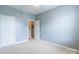 This room features a neutral carpet, light blue walls, a ceiling fan, and two white doors at 14222 Richmond Park Ave, Charlotte, NC 28277