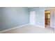 This bedroom has pale blue walls and neutral carpet, with a view to the bathroom at 14222 Richmond Park Ave, Charlotte, NC 28277