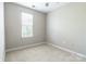 This bedroom includes a window with blinds, neutral carpet, and a ceiling fan at 14222 Richmond Park Ave, Charlotte, NC 28277