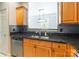This kitchen features wooden cabinets, granite counters, stainless dishwasher, and an open view into the other room at 14222 Richmond Park Ave, Charlotte, NC 28277