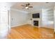 Bright living room featuring hardwood floors, fireplace, built-in shelves, and ceiling fan at 14222 Richmond Park Ave, Charlotte, NC 28277