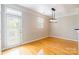 This living room has wood floors, neutral paint, a ceiling light, a door to a patio and a window with blinds at 14222 Richmond Park Ave, Charlotte, NC 28277