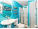 Vibrant bathroom with bright blue walls, round mirror, shelving, modern sink, and glass enclosed shower at 1505 Clarendon Pl, Rock Hill, SC 29732
